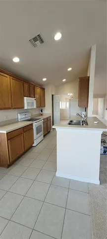 a large kitchen with a large counter top stainless steel appliances and cabinets