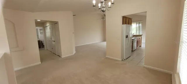 a view of a hallway with wooden floor and chandelier