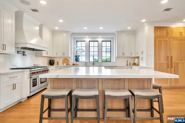 a kitchen with granite countertop white cabinets and chairs