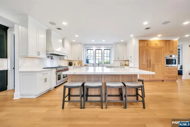 a kitchen with a table chairs wooden floors and view living room