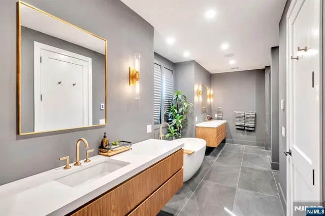 a bathroom with a tub sink and mirror