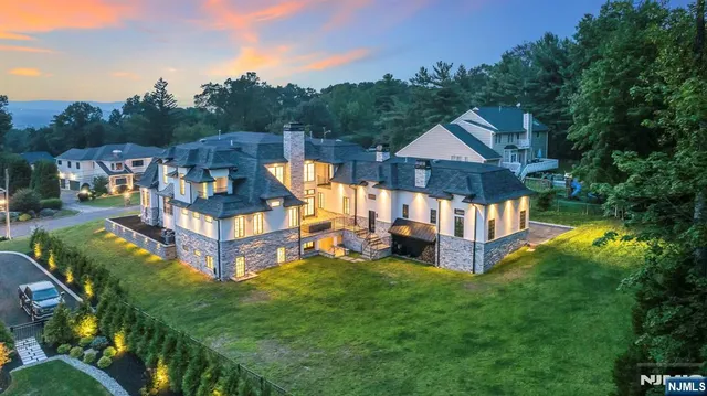 a view of a house with a big yard and large trees
