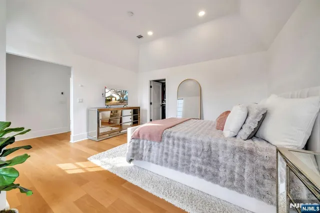 a bedroom with a large bed and a chandelier
