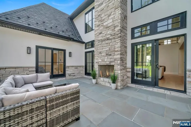 a outdoor living space with patio couch and a fireplace