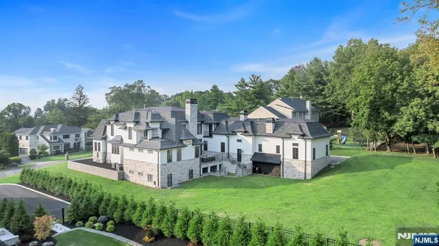 a view of a house with a big yard plants and large trees