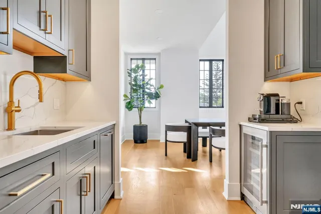 a kitchen with stainless steel appliances granite countertop a table chairs in it and wooden floors
