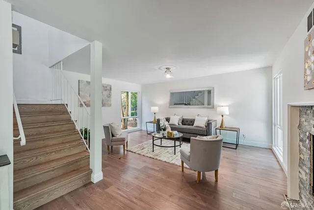 a living room with furniture and a wooden floor