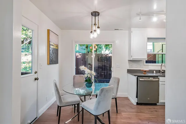 a kitchen with kitchen island stainless steel appliances a sink a stove a dining table and chairs