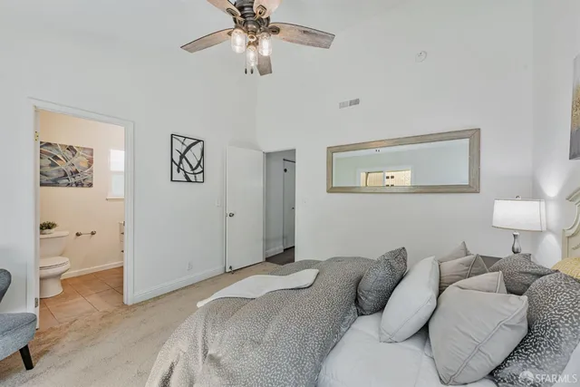 a spacious bedroom with a bed and a chandelier