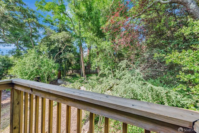 a view of staircase with two chairs and a large window with wooden floor