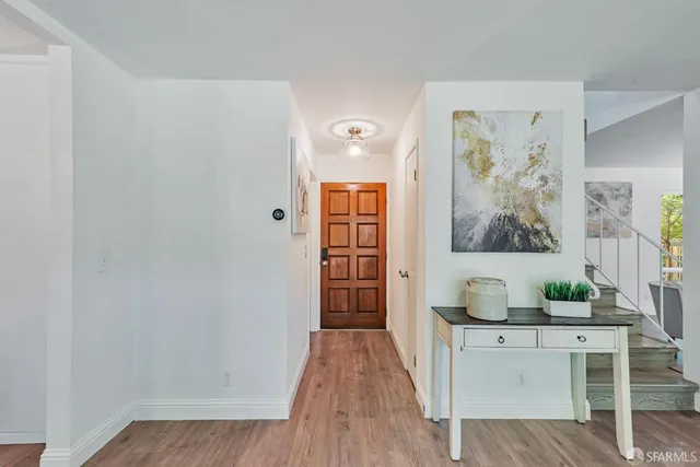 a hallway with painting on wall and wooden floor