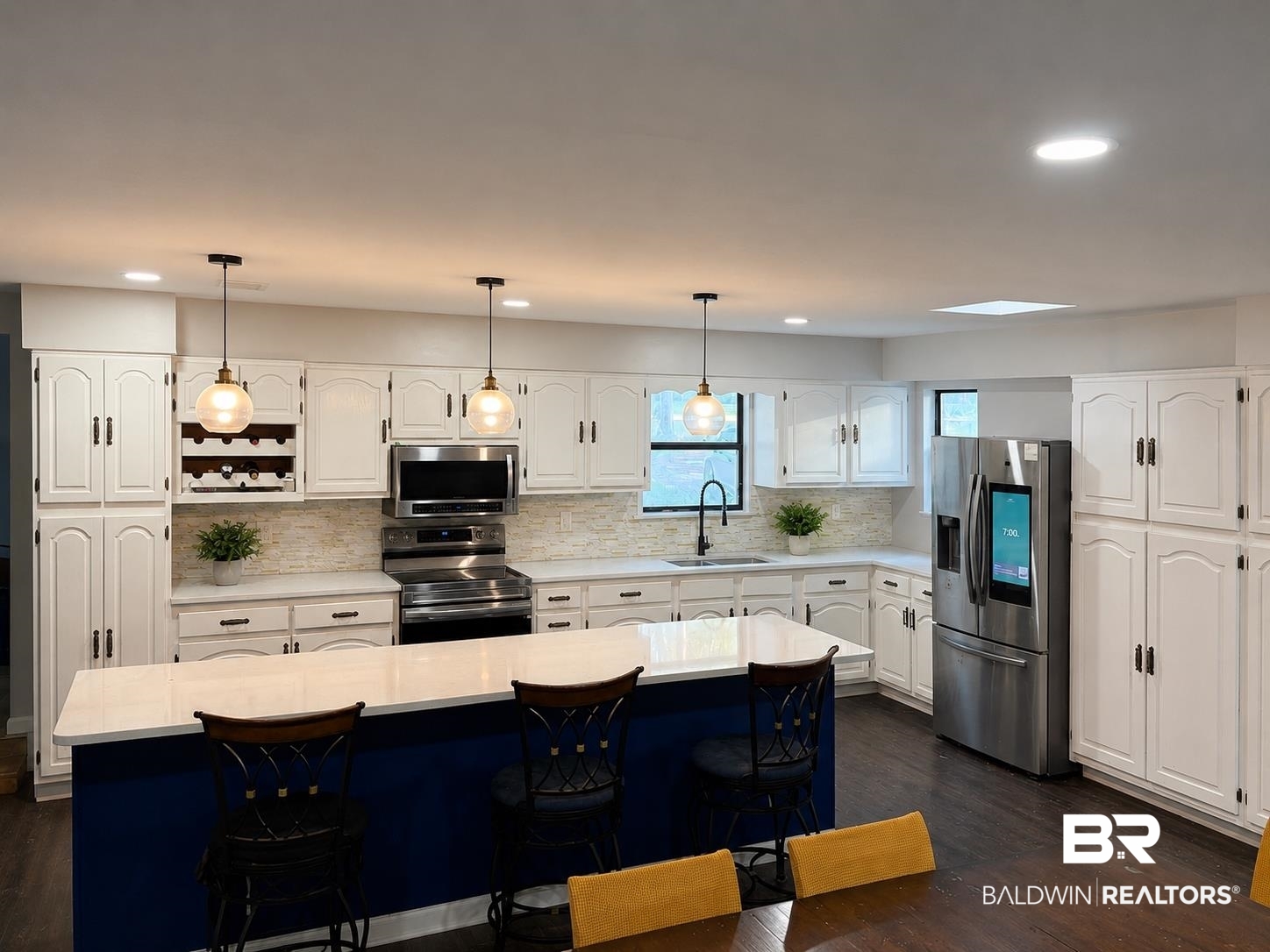 3711 Leroy Stevens Road Mobile, AL 36619 - Photo 3 of 4 Spacious kitchen featuring white cabinetry, stainless steel appliances, and a central island with countertop seating