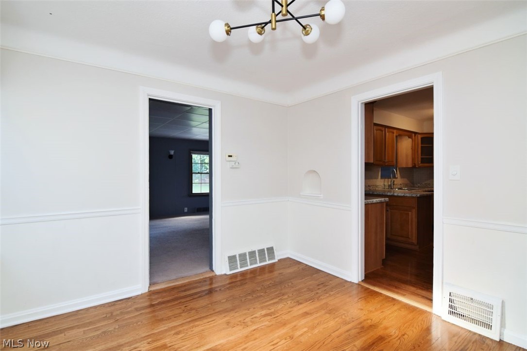 5284 Edenhurst Road Lyndhurst, OH 44124 - Photo 21 of 50 Hardwood flooring, crown molding, chair rail detailing, recessed wall niche, and a contemporary ceiling light fixture