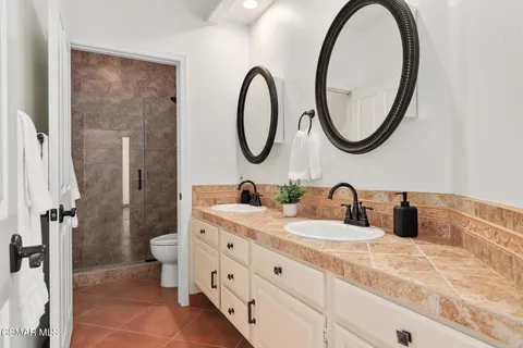 a bathroom with a granite countertop sink mirror and toilet