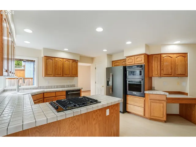 a kitchen with stainless steel appliances a stove a sink and a refrigerator
