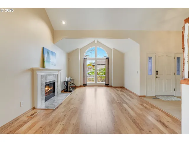 a view of empty room with fireplace and wooden floor