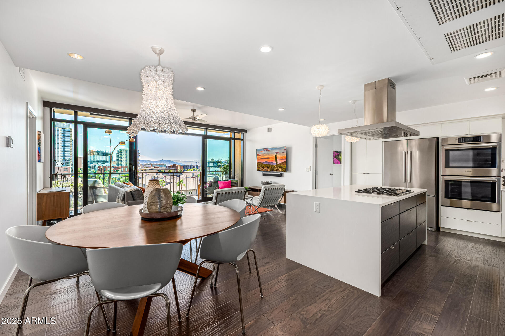 a kitchen with stainless steel appliances a dining table chairs stove and white cabinets