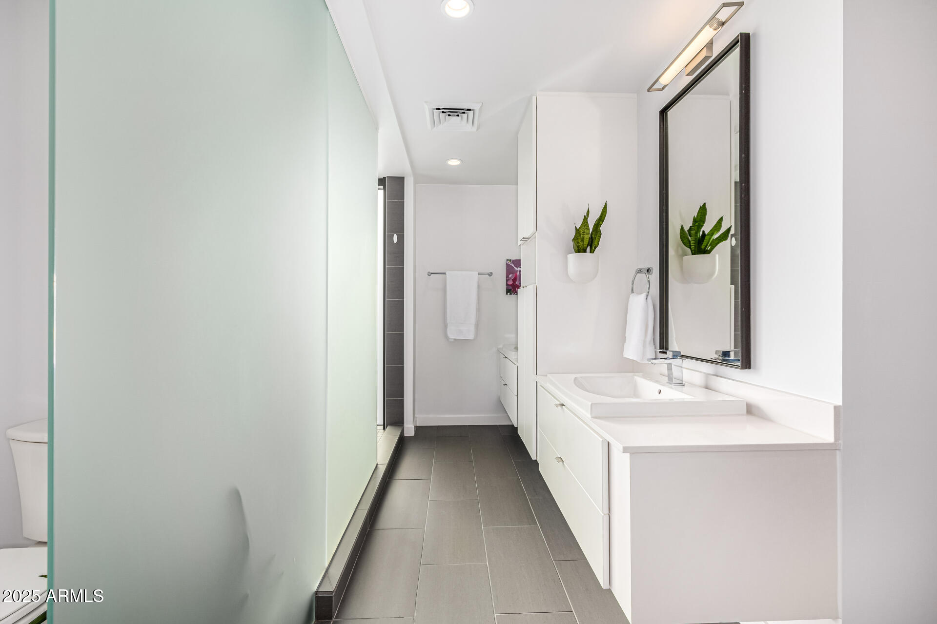 200 West Portland Street, Unit 827 Phoenix, AZ 85003 - Photo 23 of 111 a view of a hallway with mirror and a bathroom