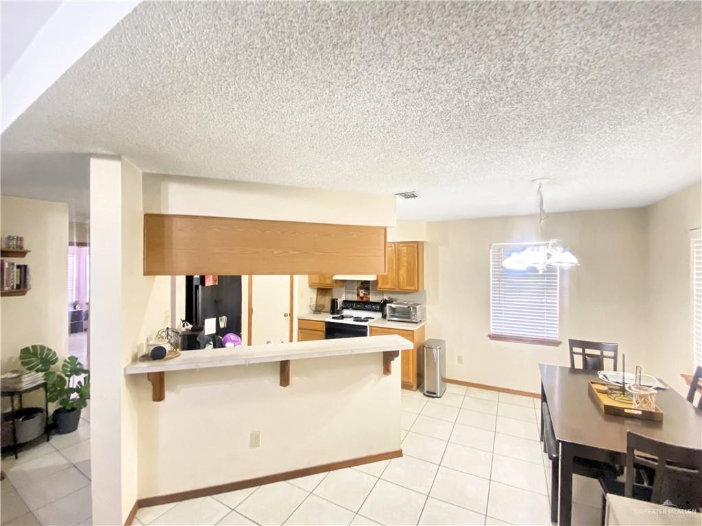 483 Whalen Road San Benito, TX 78586 - Photo 2 of 10 a kitchen with kitchen island granite countertop a sink cabinets and window