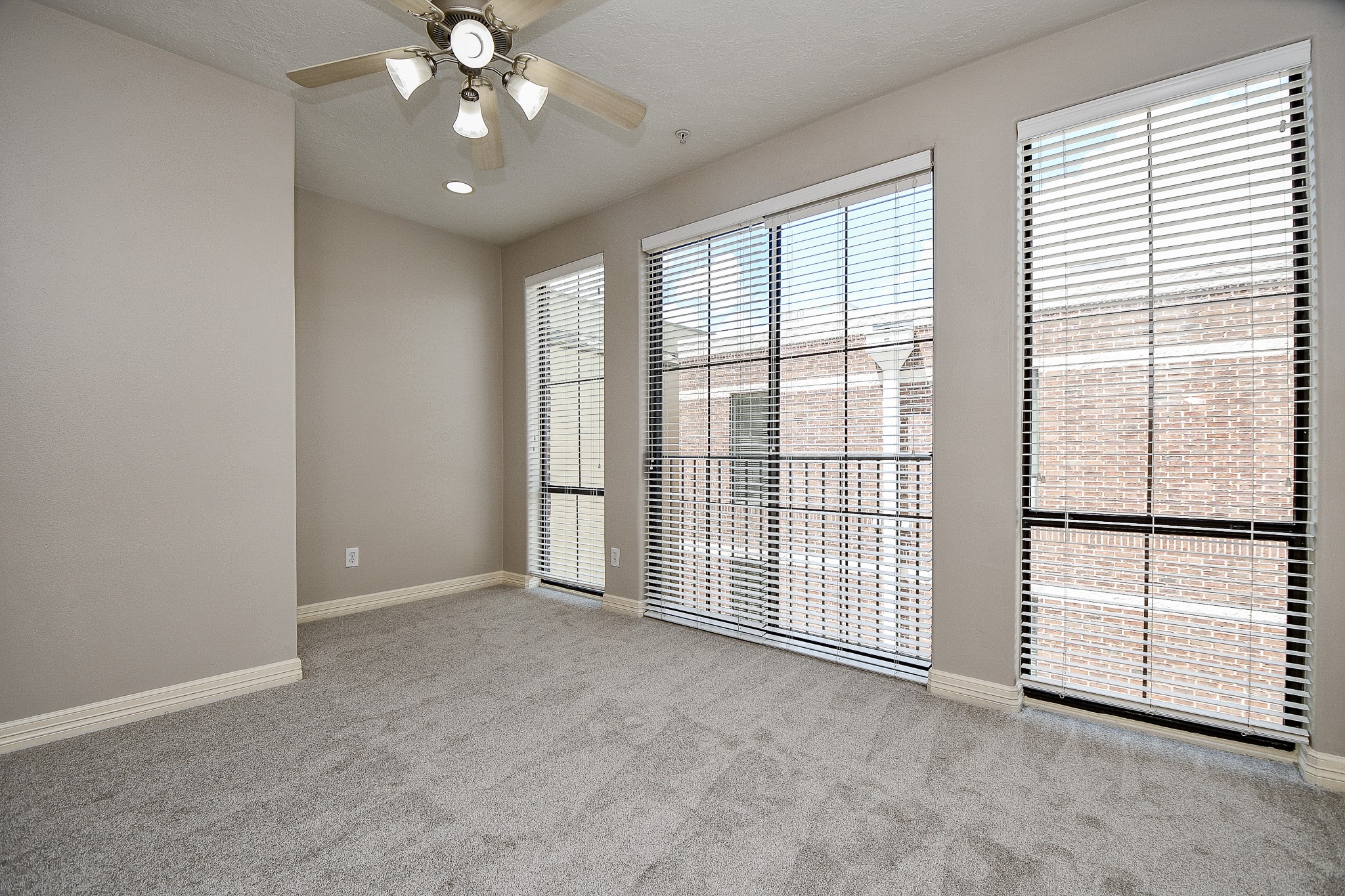 118 McGowen Street, Unit K Houston, TX 77006 - Photo 17 of 32 Brand new carpet and recently painted primary bedroom with high ceilings, floors to ceiling windows and little work nook for work desk