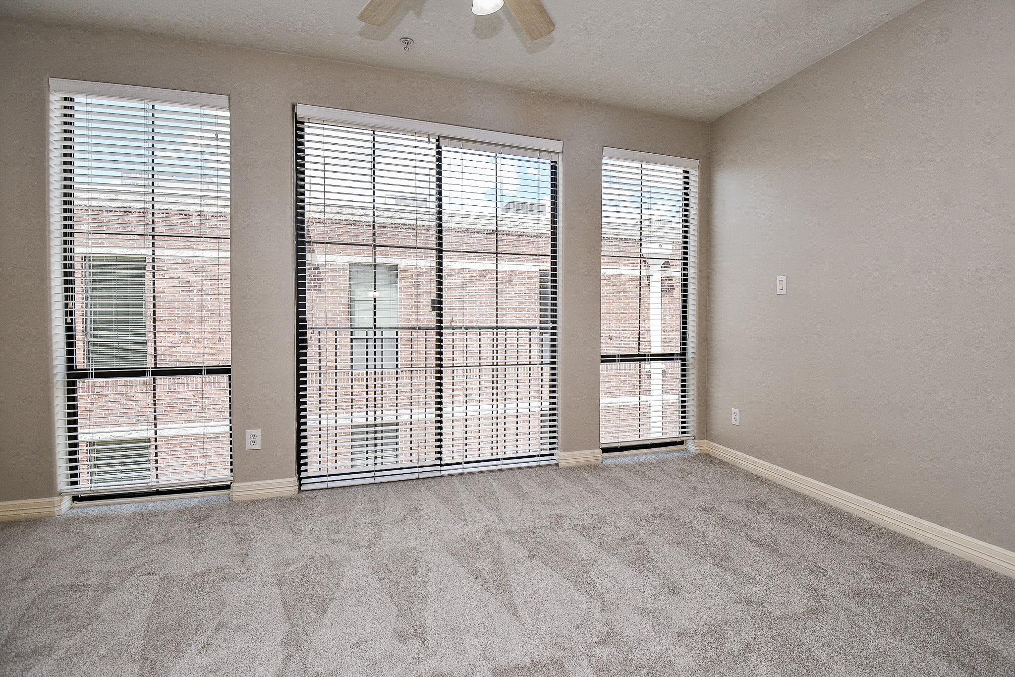 118 McGowen Street, Unit K Houston, TX 77006 - Photo 18 of 32 Brand new carpet and recently painted primary bedroom with high ceilings, floors to ceiling windows and little work nook for work desk