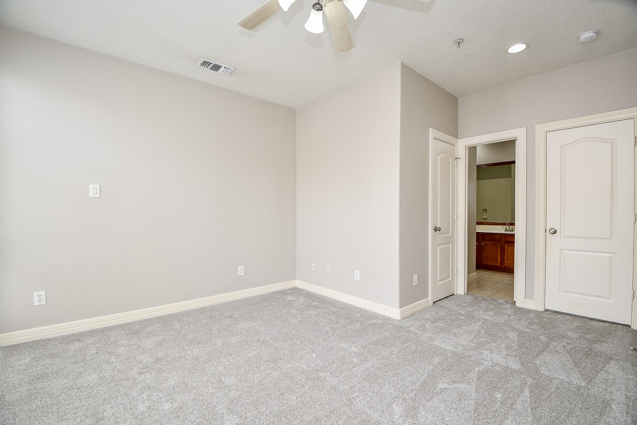 118 McGowen Street, Unit K Houston, TX 77006 - Photo 20 of 32 Brand new carpet and recently painted primary bedroom with high ceilings, floors to ceiling windows and little work nook for work desk