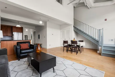 a living room with furniture and a dining table with kitchen view