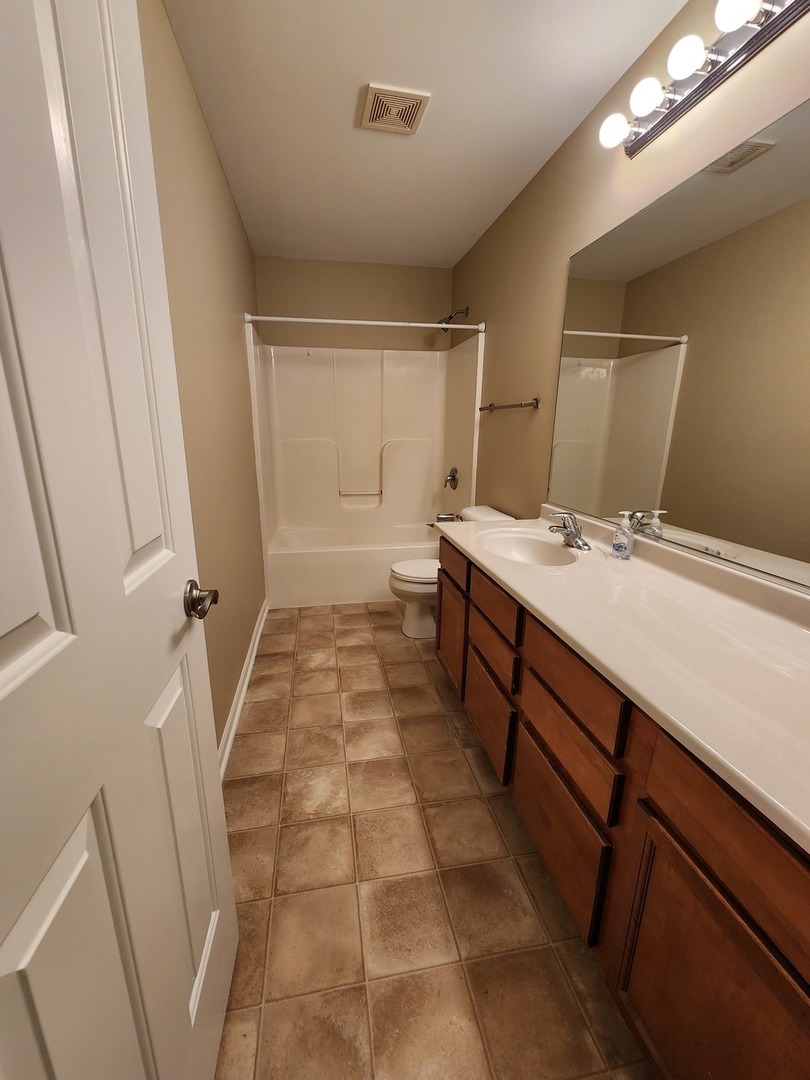 618 Caleb Drive, Unit 618 Ottawa, IL 61350 - Photo 8 of 10 a bathroom with a sink a toilet a mirror and vanity
