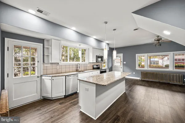 a large white kitchen with a large window