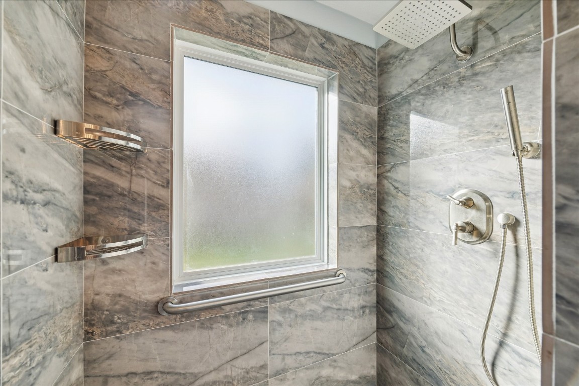 24919 Bovington Drive Spring, TX 77389 - Photo 13 of 21 The primary shower is sleek and equipped with shelving, oversized shower head and shower wand.