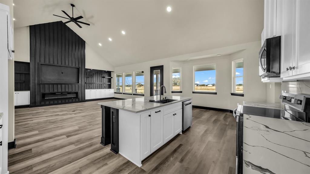 300 Jupiter Trail Weatherford, TX 76088 - Photo 13 of 33 a kitchen with stainless steel appliances sink cabinets and wooden floor