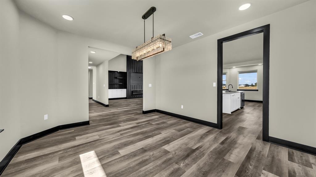 300 Jupiter Trail Weatherford, TX 76088 - Photo 18 of 33 a view of a room with wooden floor a ceiling fan and kitchen