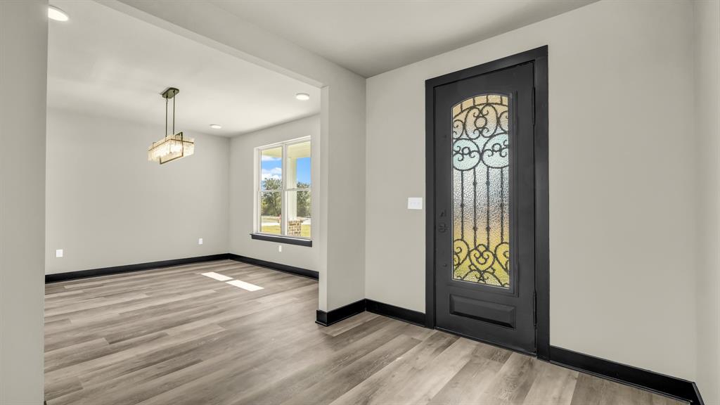 300 Jupiter Trail Weatherford, TX 76088 - Photo 8 of 33 an empty room with wooden floor windows and entrance