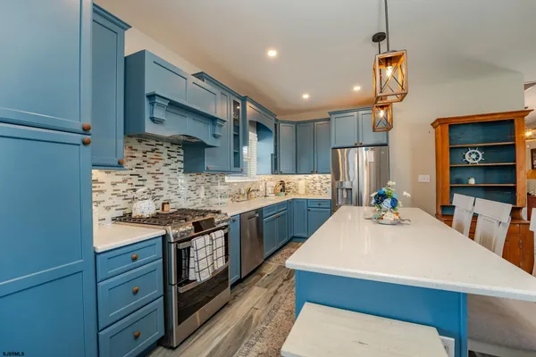 a kitchen with kitchen island a sink stove and refrigerator