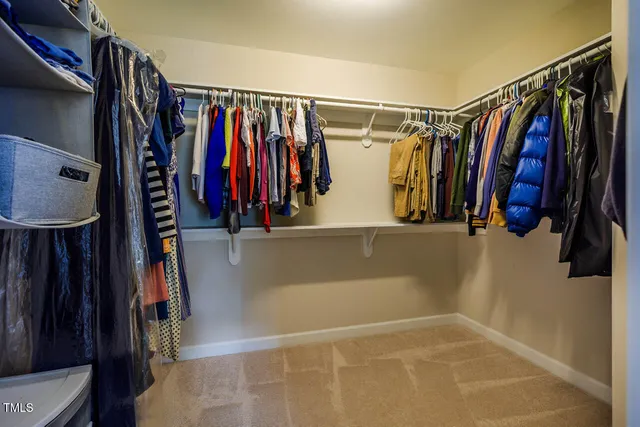 a view of walk in closet with clothes and shoes