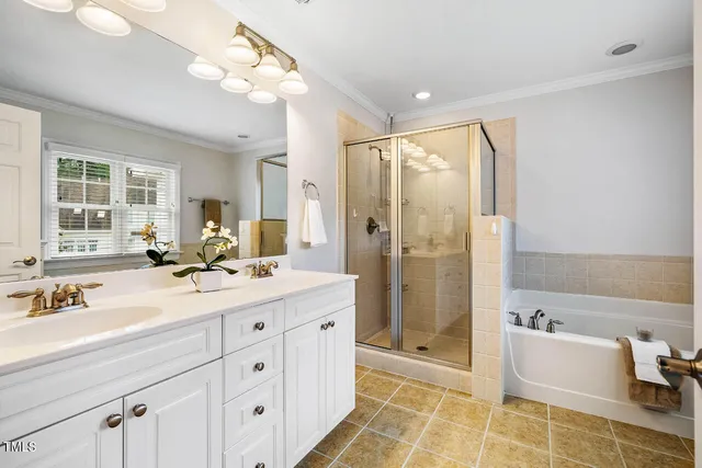 a spacious bathroom with a double vanity sink a mirror a bathtub and next to a window