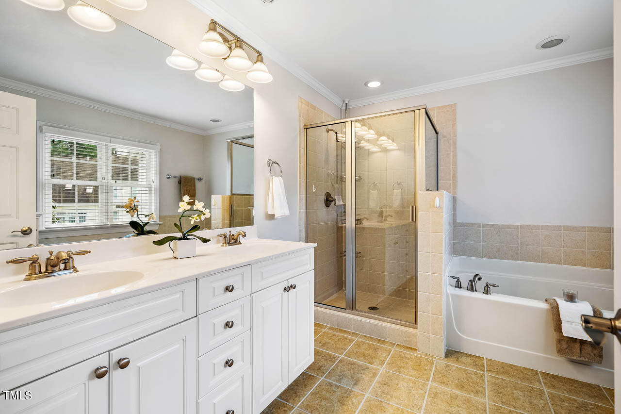 5515 South Roxboro Street, Unit 4 Durham, NC 27713 - Photo 18 of 34 a spacious bathroom with a double vanity sink a mirror a bathtub and next to a window