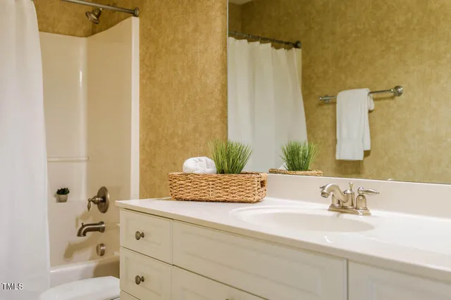 a bathroom with a granite countertop sink a mirror and shower