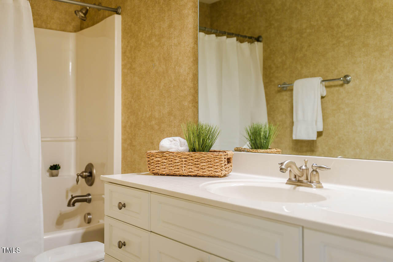 5515 South Roxboro Street, Unit 4 Durham, NC 27713 - Photo 28 of 34 a bathroom with a granite countertop sink a mirror and shower