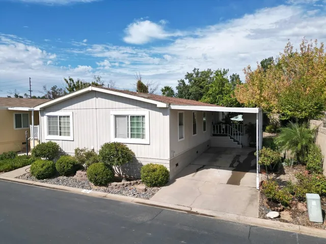 a front view of a house with a yard and trees