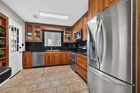 a kitchen with granite countertop a refrigerator and a sink