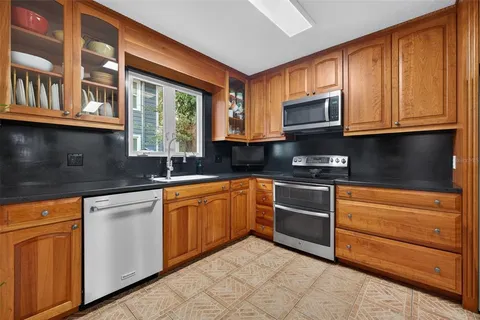 a kitchen with stainless steel appliances granite countertop a stove and cabinets