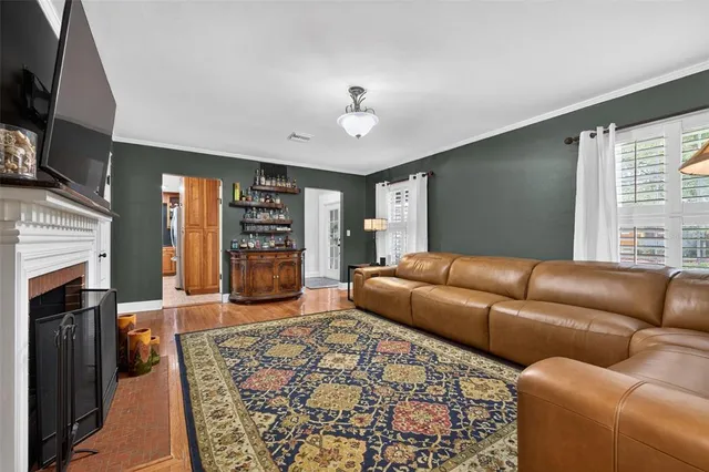 a living room with furniture a flat screen tv and a fireplace
