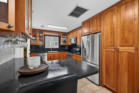a kitchen with sink a refrigerator and chairs