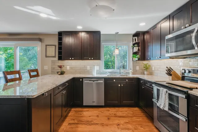 a large kitchen with stainless steel appliances granite countertop a sink stove and refrigerator