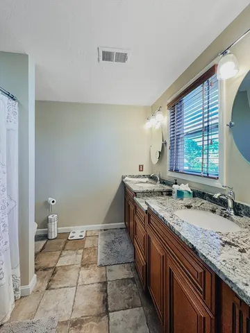 a bathroom with a granite countertop sink and a mirror