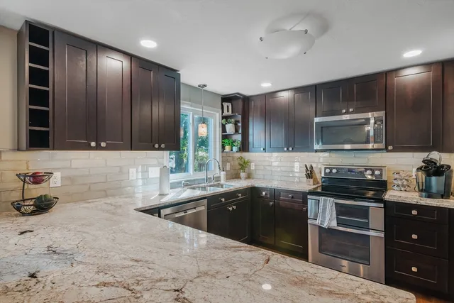 a kitchen with stainless steel appliances granite countertop a sink stove and oven
