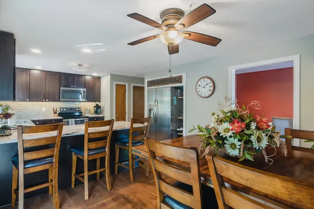 a room with stainless steel appliances kitchen island granite countertop furniture and a dining table
