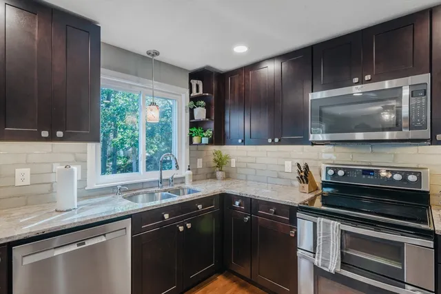 a kitchen with stainless steel appliances a sink stove and microwave