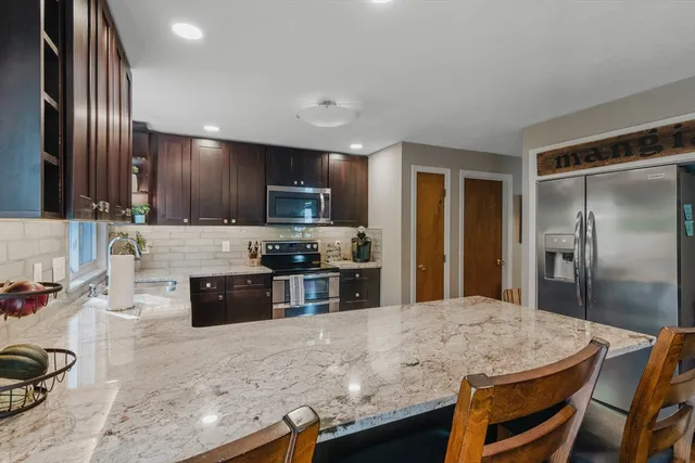 a kitchen with stainless steel appliances granite countertop a stove refrigerator sink and cabinets